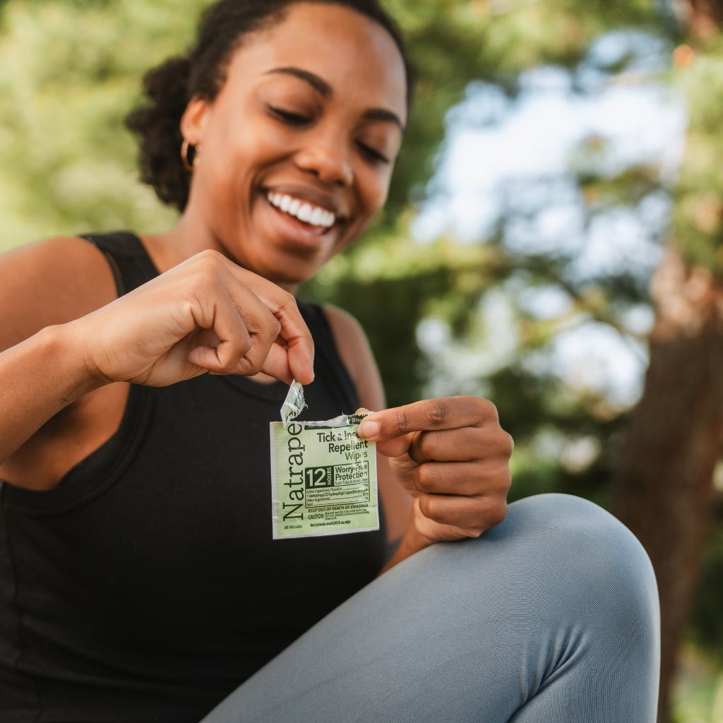 Woman holding a Natrapel wipe outdoors