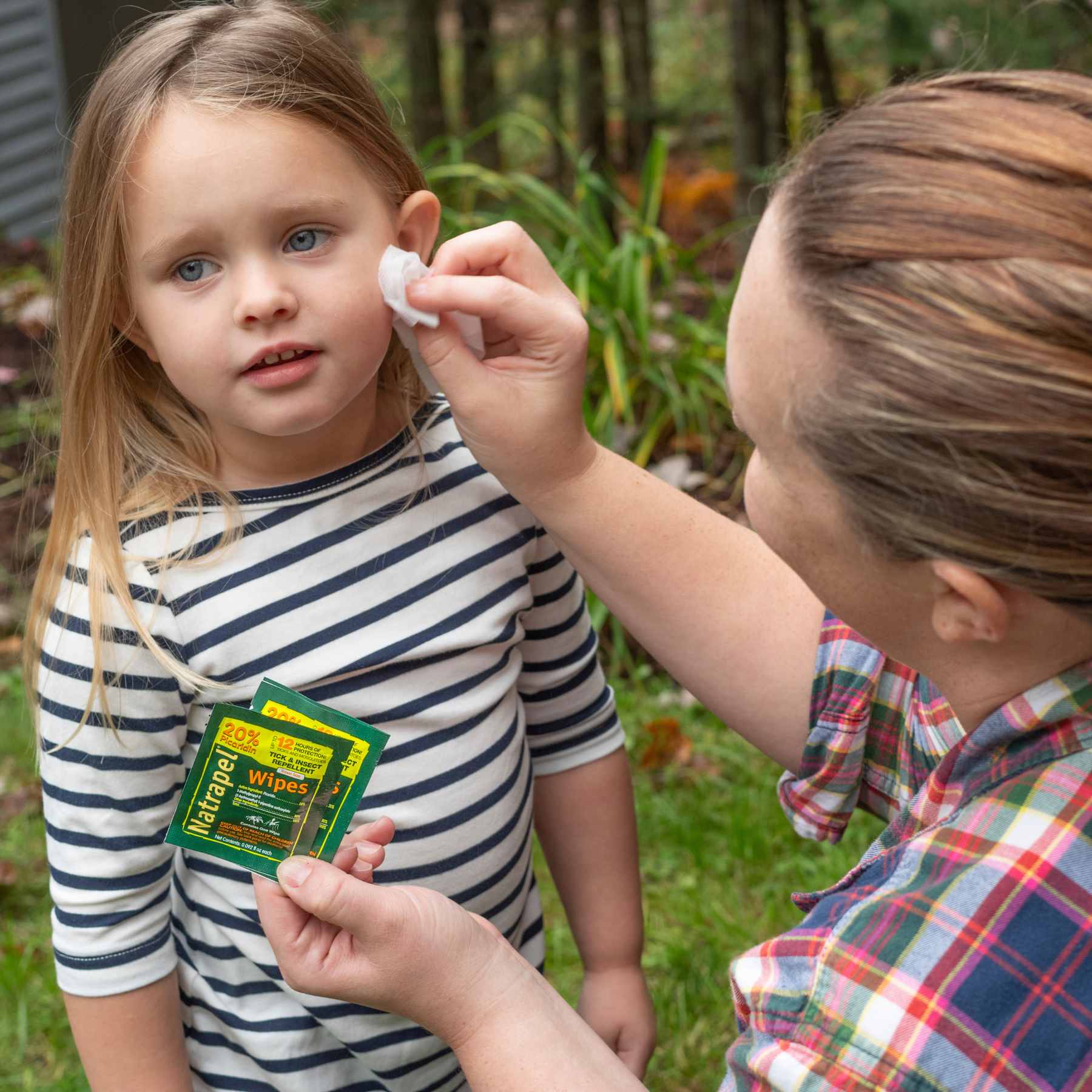 Woman applying Natrapel Picaridin Insect Repellent Wipes to child's face