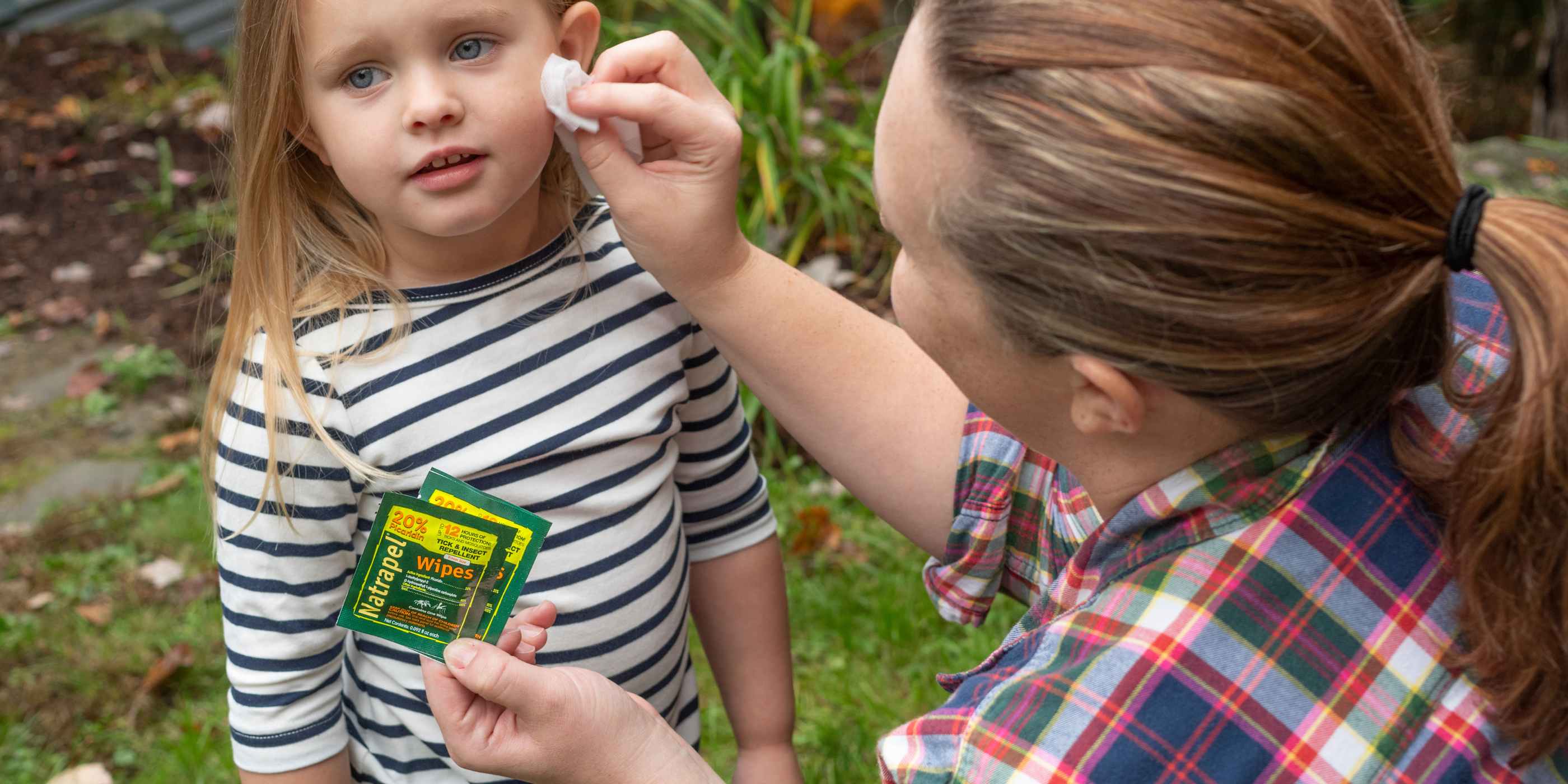 Woman applying Natrapel Picaridin Insect Repellent Wipes to child's face