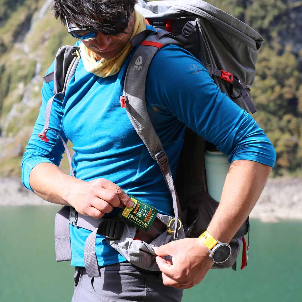 Natrapel Picaridin Tick & Insect Repellent Wipes hiking man pulling individual wipe out of pocket in front of water